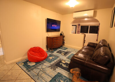 The living room features a big screen TV and a comfortable, contemporary leather sofa and love seat.